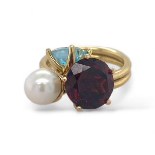 Gouden tuimelwisselring met drie hangende zettingen met sky blue topaas, granaat en parel