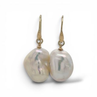 Elegante gouden oorhangers met twee natuurlijke nuclea parels met een organische vorm en een schitterende parelmoerglans.