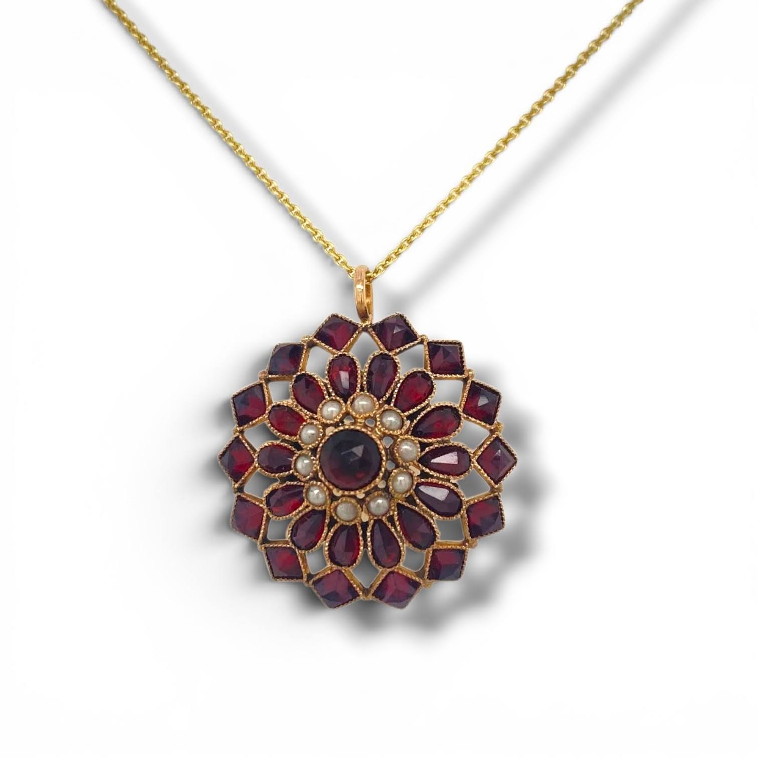 Antieke gouden hanger met granaatstenen en parels in opengewerkt bloemmotief.