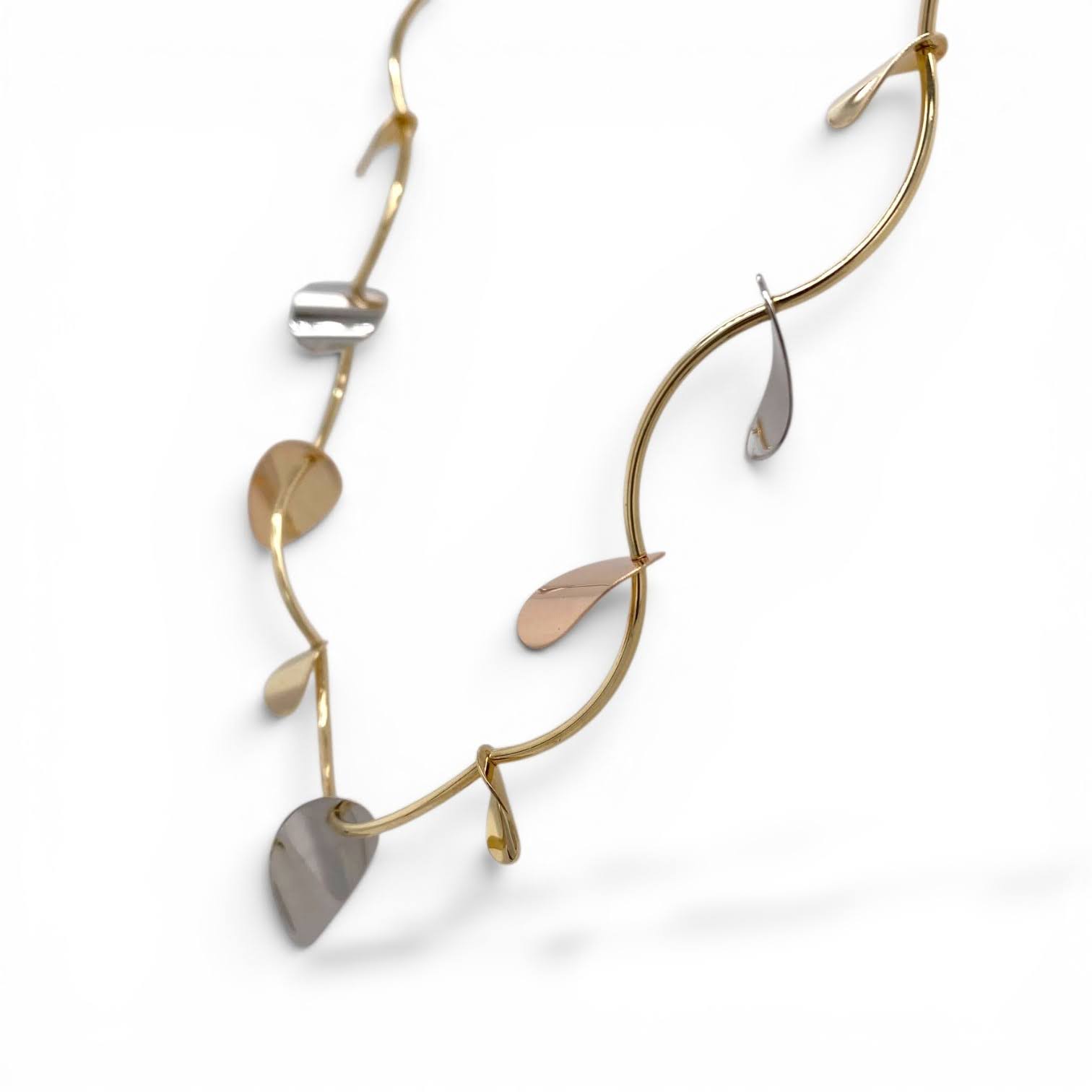 Driekleurig gouden collier met bladvormige hangers van geel-, wit- en roségoud.