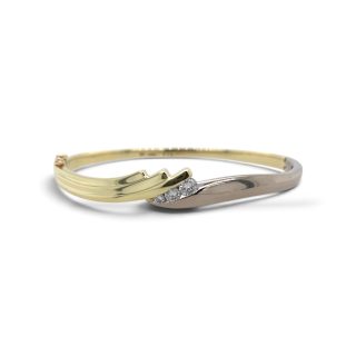 Bicolor gouden slavenarmband met drie diamanten en modern bypass ontwerp.