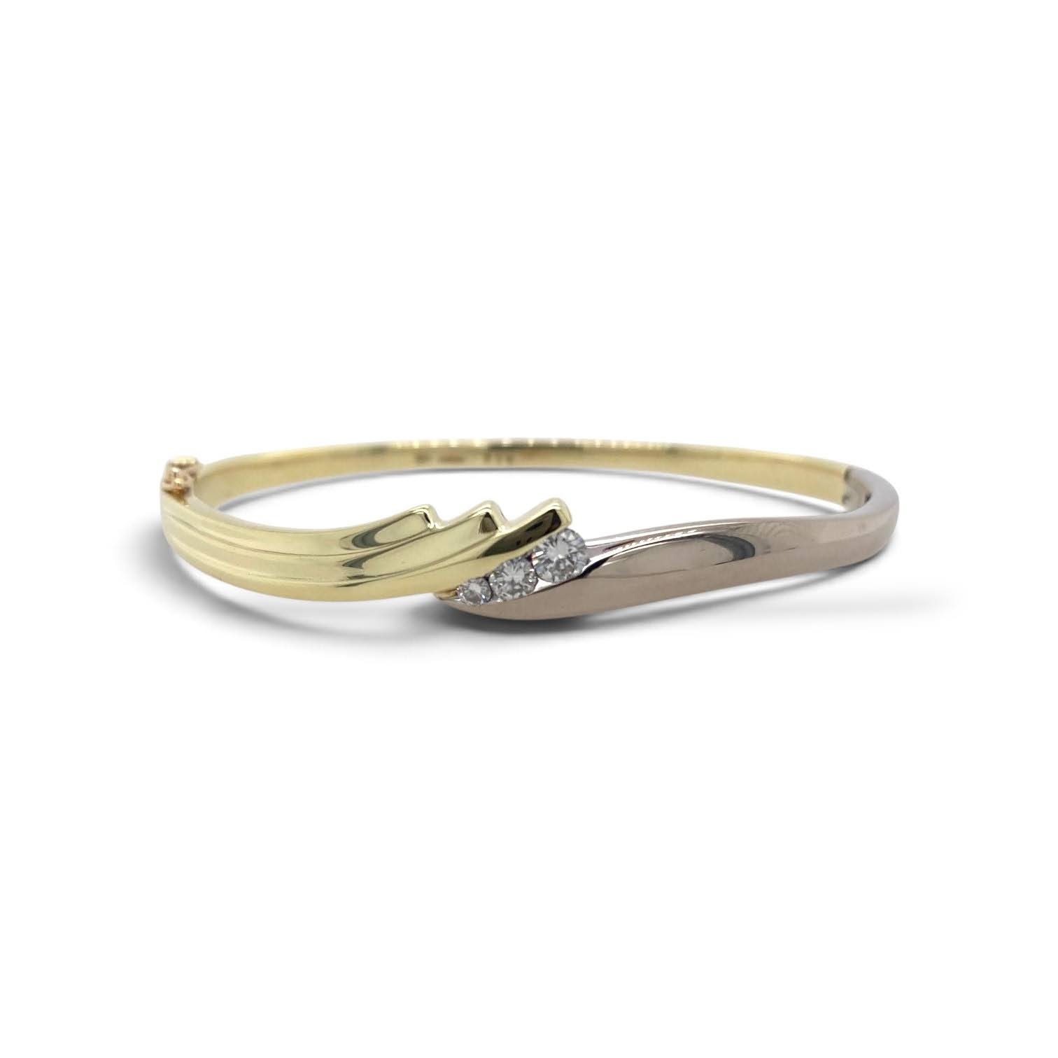 Bicolor gouden slavenarmband met drie diamanten en modern bypass ontwerp.