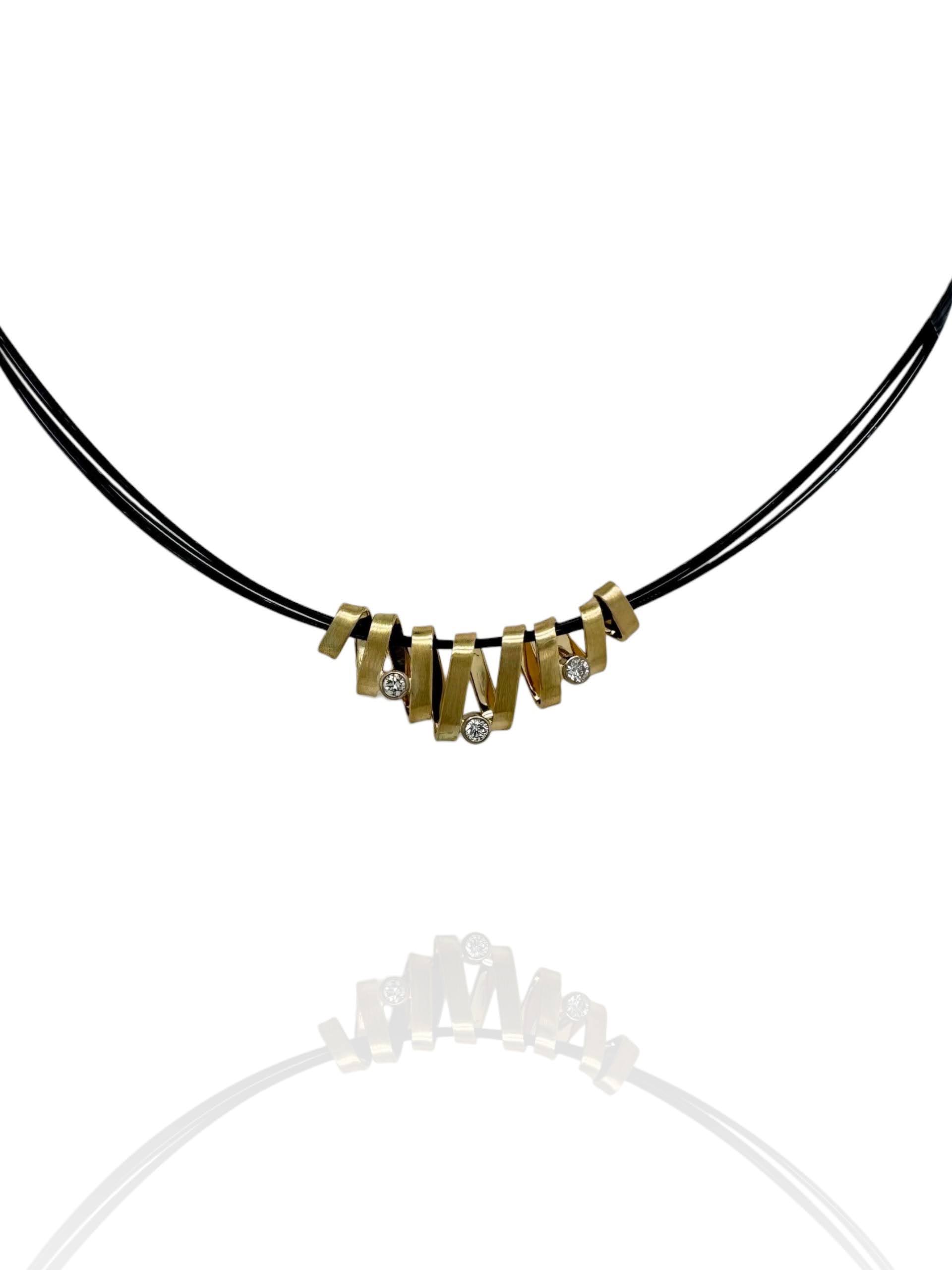 14 karaat gouden wikkelhanger met drie diamanten aan een zwart nylon collier