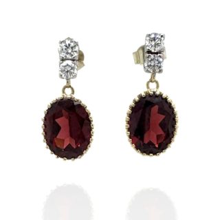 Gouden oorhangers met twee diamanten in witgoud en een granaat in een geelgouden kranszetting.